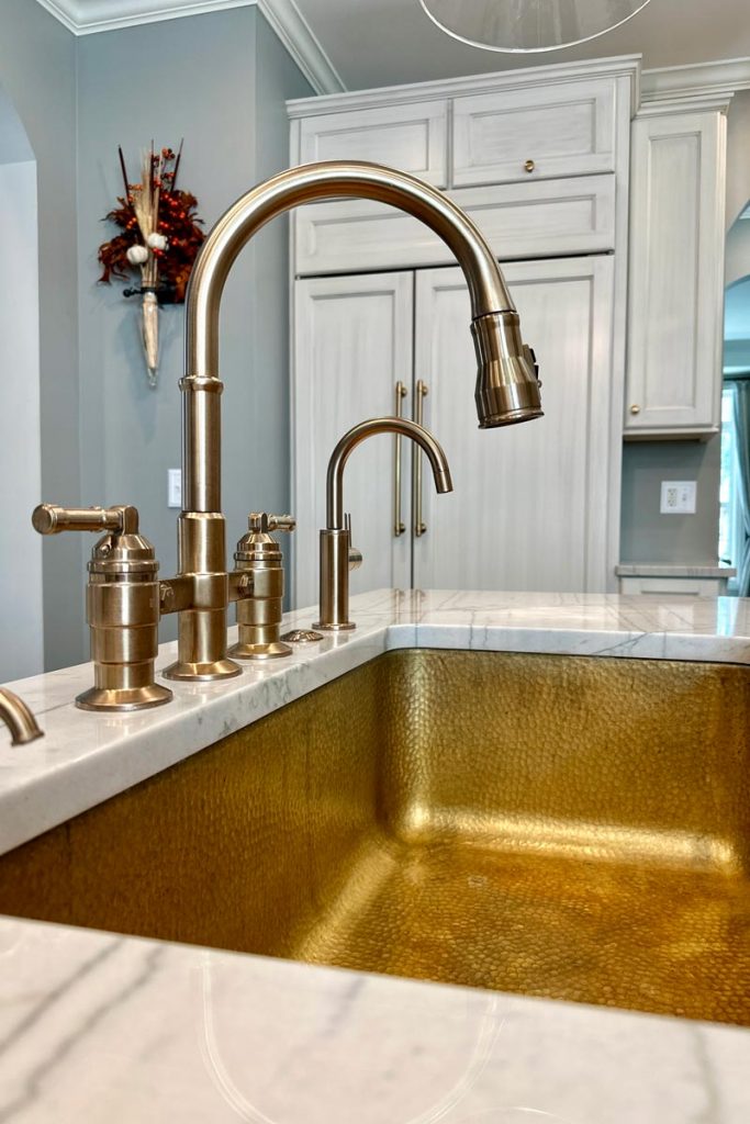 gold sink with marble white countertops