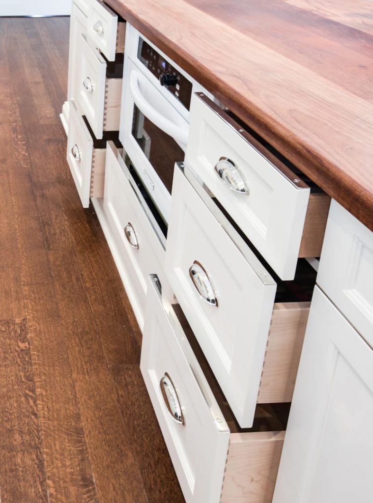 white cabinetry with wood countertops and silver accents