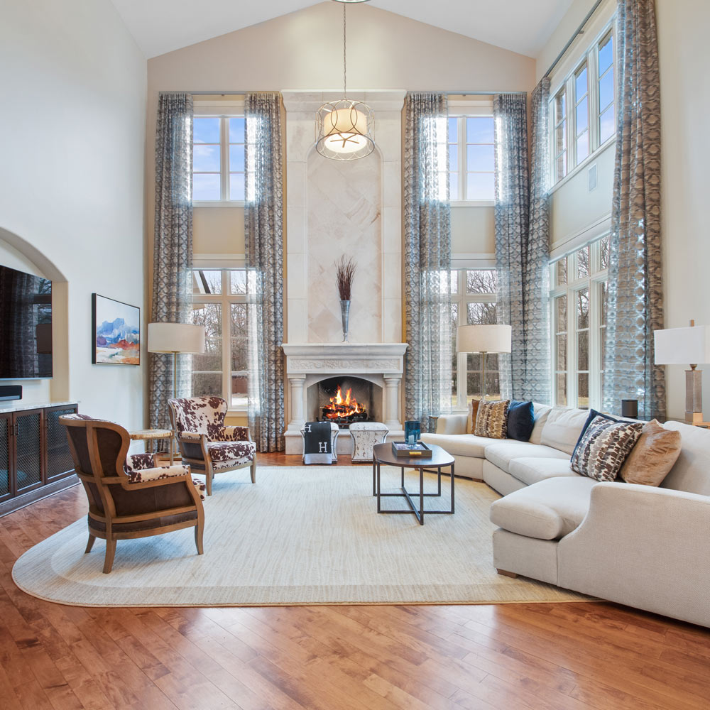 living room with modular sofa, large floor to ceiling windows and custom made fireplace